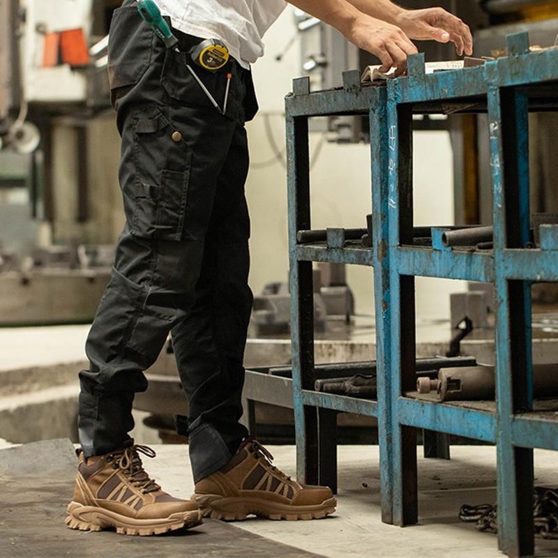 Werkstattboden: Schwarze Mid-Tops am Fuß, Schritt über Metallgitter