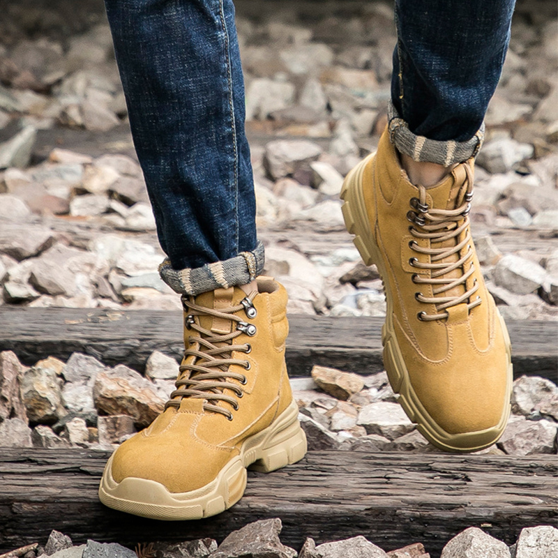 Gelber Stiefel getragen, steht auf Gleisschotter – Seitenansicht