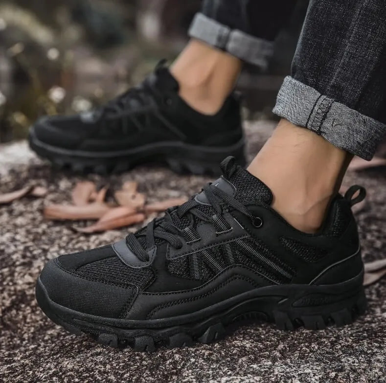 Schwarzer Schuh getragen auf Waldboden, Seitenansicht